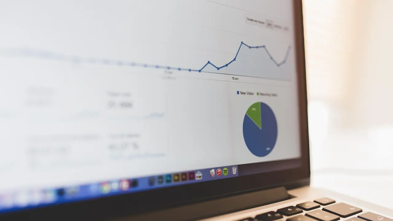 A laptop screen displaying line and pie charts of financial performance.