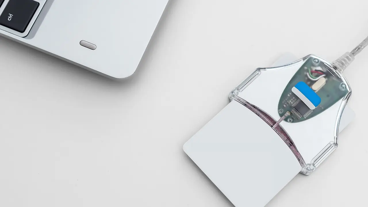 A USB cryptographic token beside a laptop, used to hold a digital signature certificate.