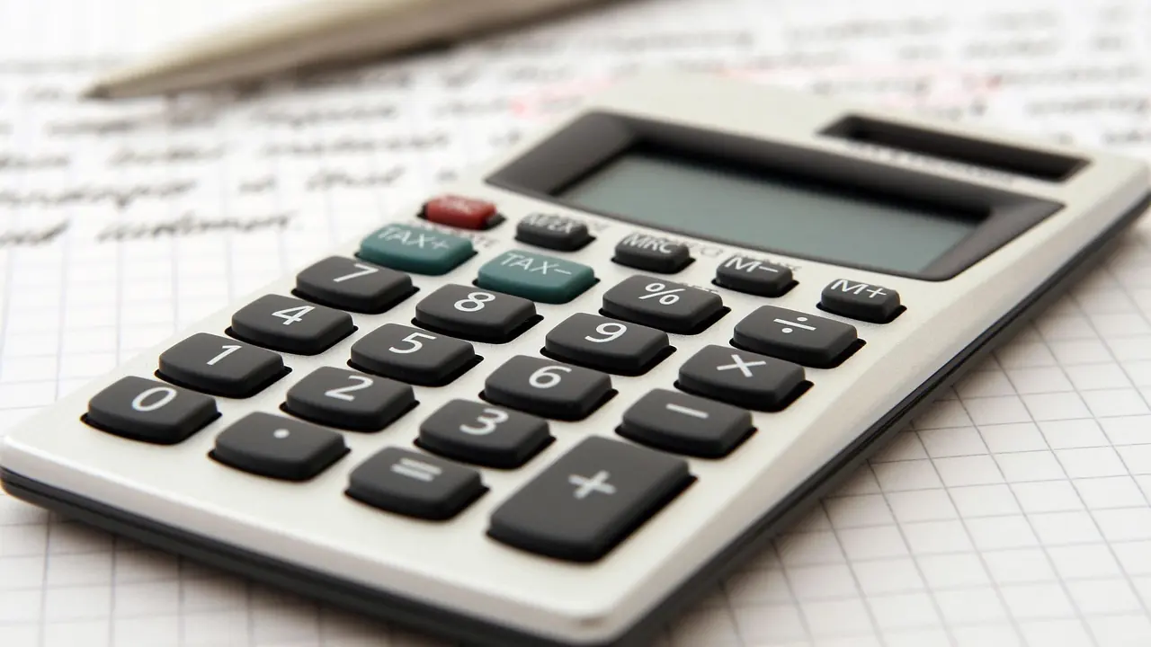 Close-up of a calculator keypad on a sheet of ruled working paper.
